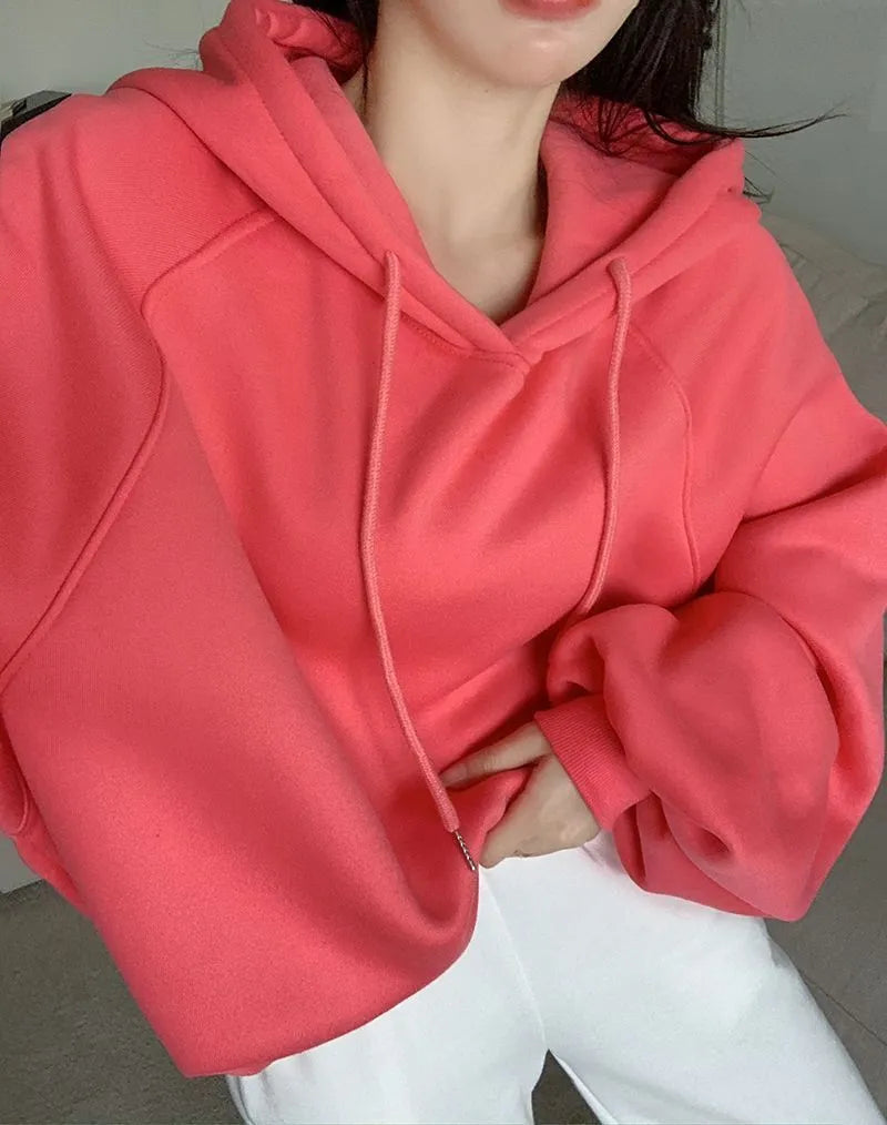 Watermelon red women's loose hooded sweater made from mulberry silk fabric on a hanger.