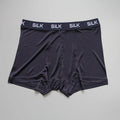 Men's loose-fitting silk shorts in navy blue, shown laid flat to display mid-waist design.
