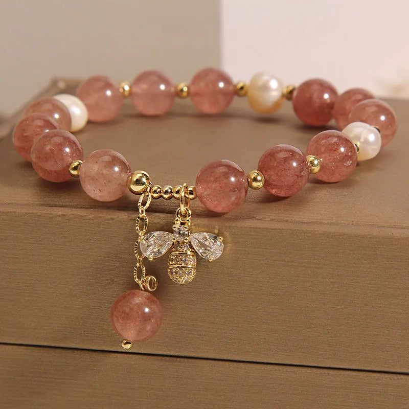 Women's pink strawberry quartz and white freshwater pearl bracelet with zircon accents on wrist