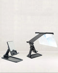 Black folding mobile phone screen amplifier and adjustable holder on a desktop, magnifying a smartphone display.