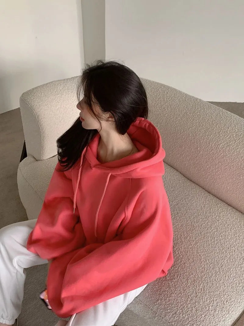 Watermelon red women's loose hooded sweater made from mulberry silk fabric on a hanger.