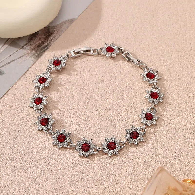 Gold and silver electroplated flower bracelets with coloured gems and crystals on a zinc alloy base.