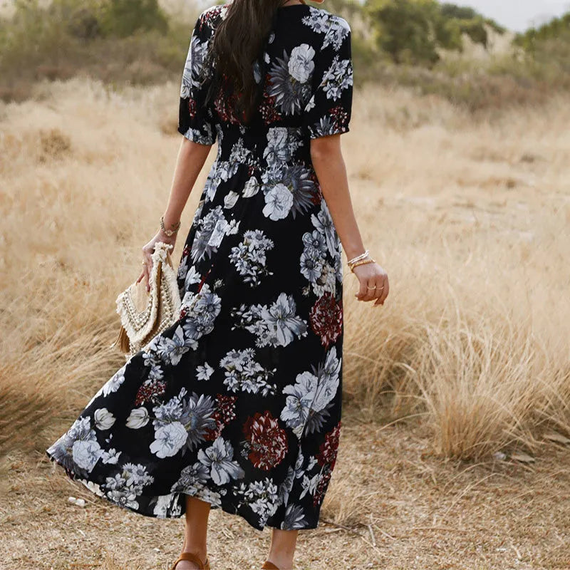 Yellow floral print summer dress on a woman, showing V-neck, short sleeves, elastic waist, and a flowing mid-length skirt.