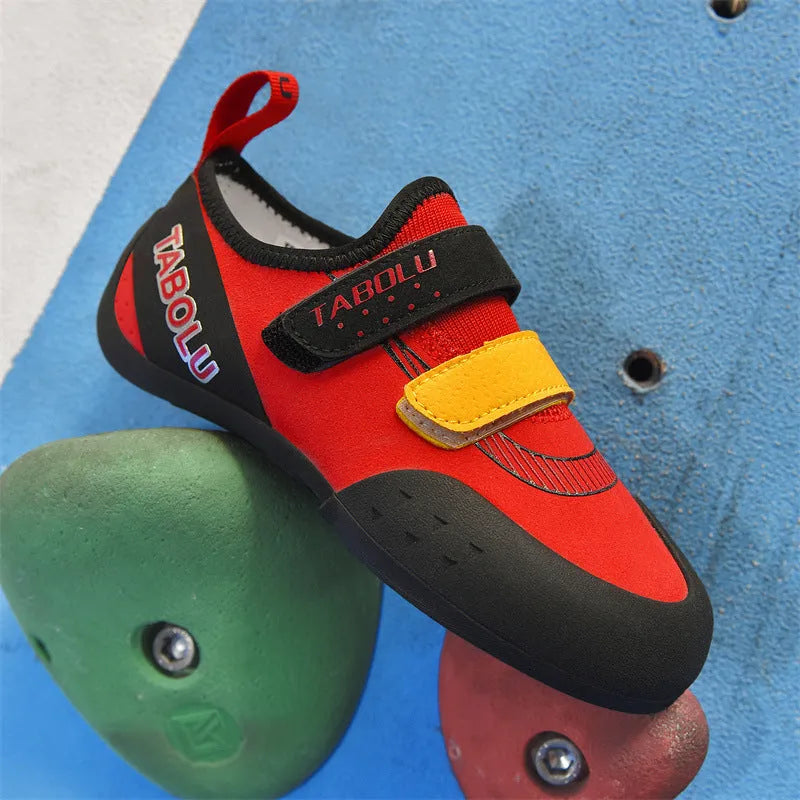 Beginner unisex rock climbing shoes with black and red colourway, showing Velcro strap and rubber sole.