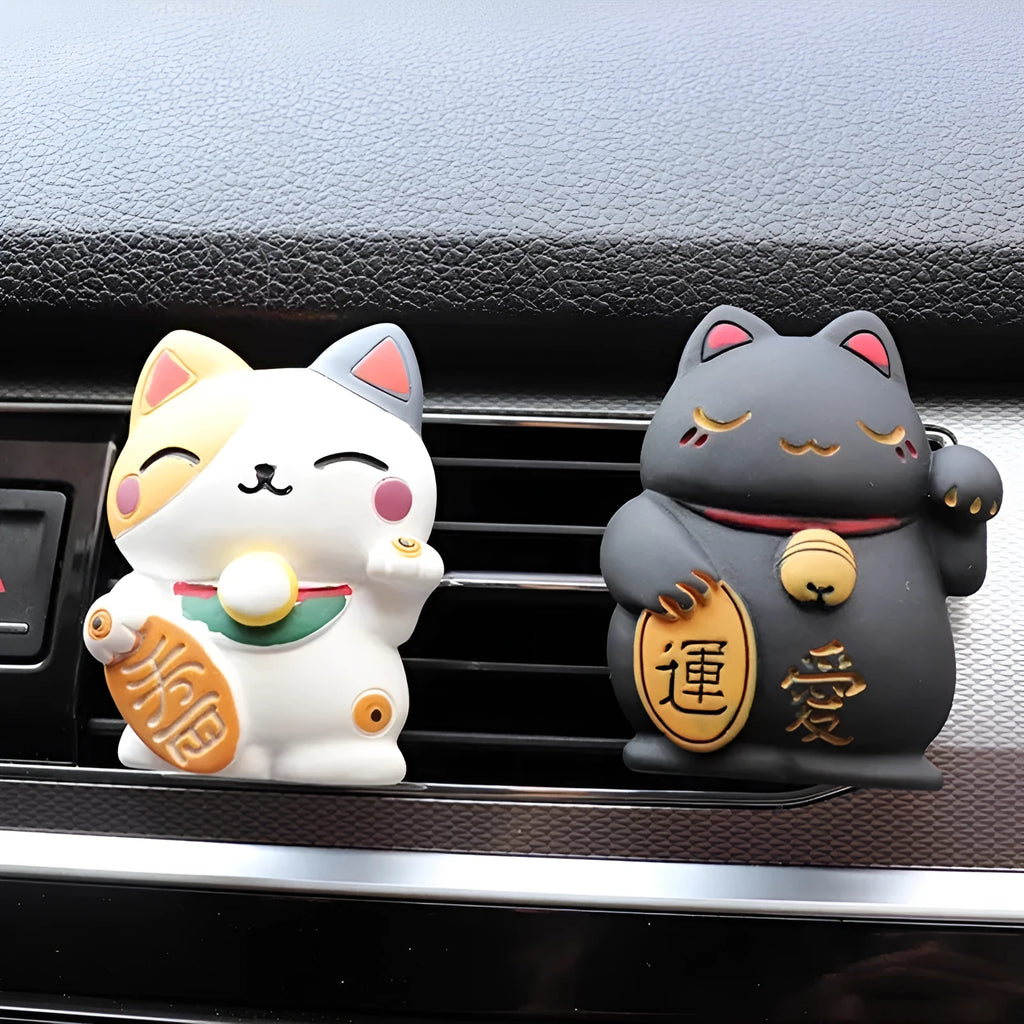 Black and white resin fortune cat decorative clip for car air conditioning vent with aromatherapy function.