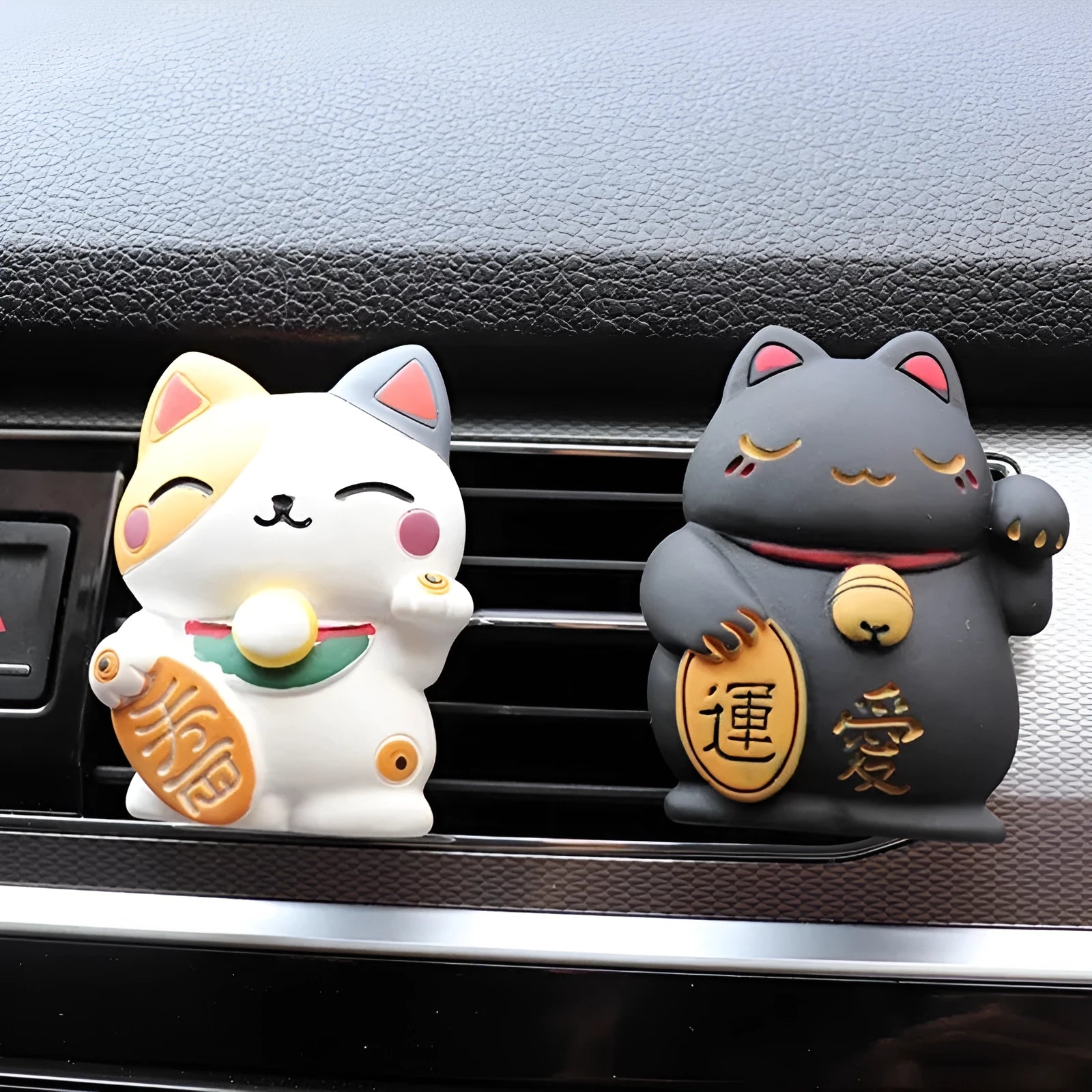 Black and white resin fortune cat decorative clip for car air conditioning vent with aromatherapy function.