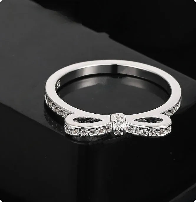 Silver bow-shaped ring with rhinestone and zircon crystal decoration on model hand