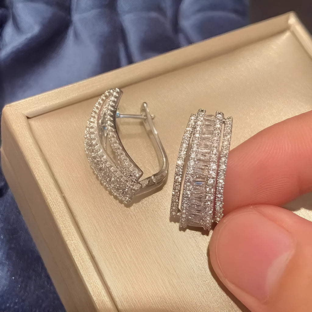 A pair of women's geometric stud earrings with inlaid zircon stones in a white gold colour finish.
