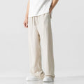 Man wearing beige straight-leg cropped linen trousers with a drawstring waist.