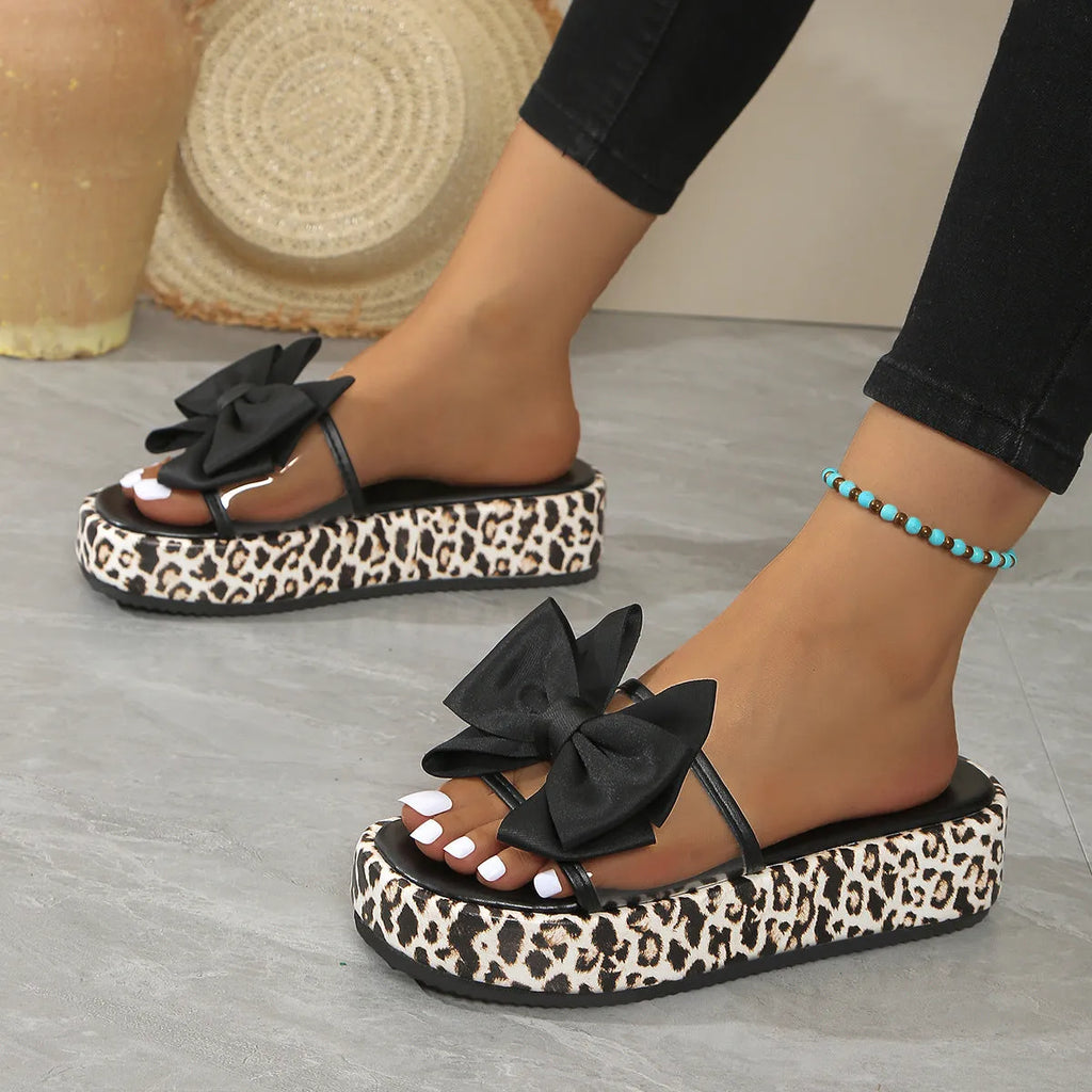 Women's black and white leopard print beach slippers with a thick sole and round toe design.