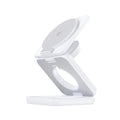 White foldable magnetic wireless phone charger holder with 360-degree rotating base on a desk.