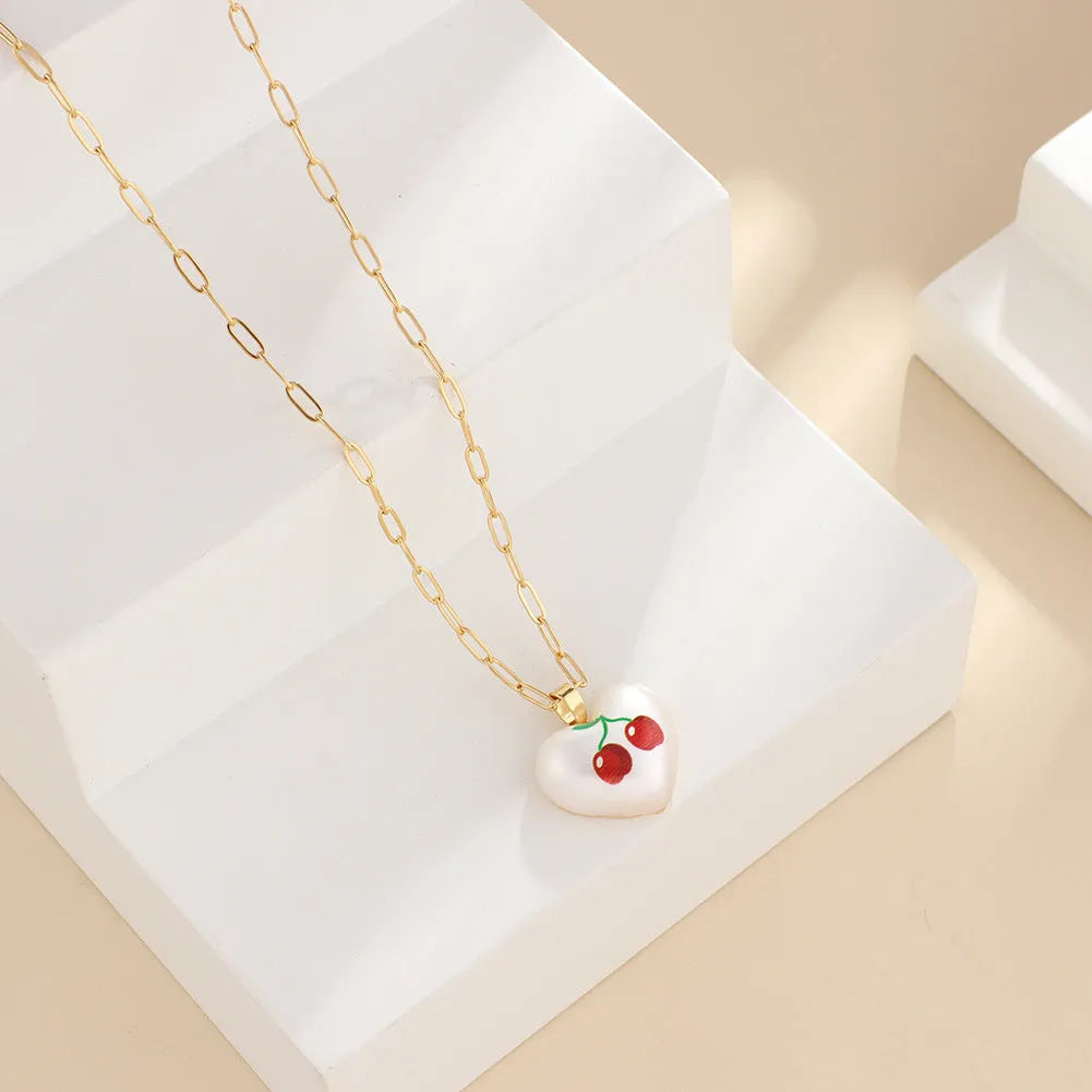 Geometric heart-shaped necklace with a choice of strawberry, pineapple, apple, pear or cherry pendant on an adjustable chain.