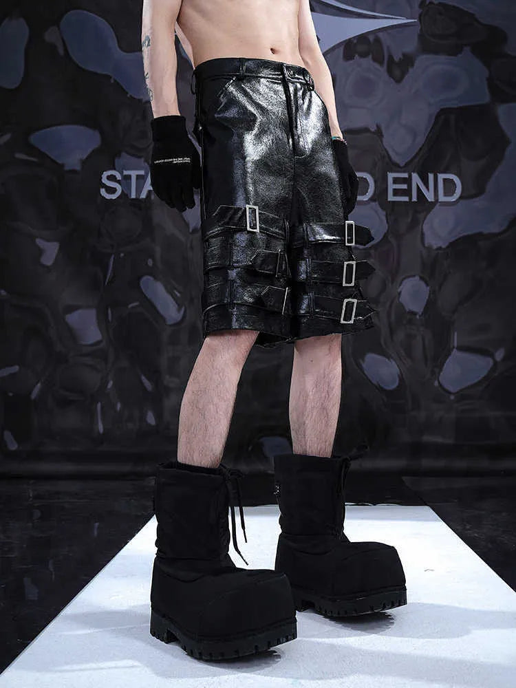 Men's black PU leather cropped shorts on a hanger, showing low waist and casual fit.
