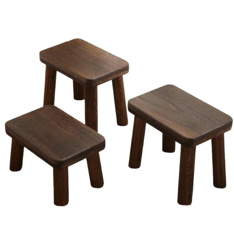 Distressed solid wood changing stool with bracket structure in a rustic finish.