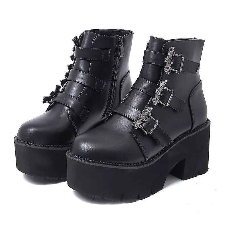 Black women's punk ankle boots with bat buckle detail, chunky heel, and side zipper.