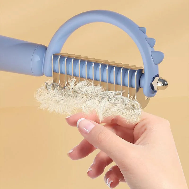 Blue dinosaur-shaped self-cleaning cat brush with double-sided grooming head