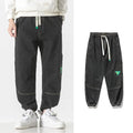Men's loose-fit tapered cotton trousers in black, blue, or grey colours with mid waist design
