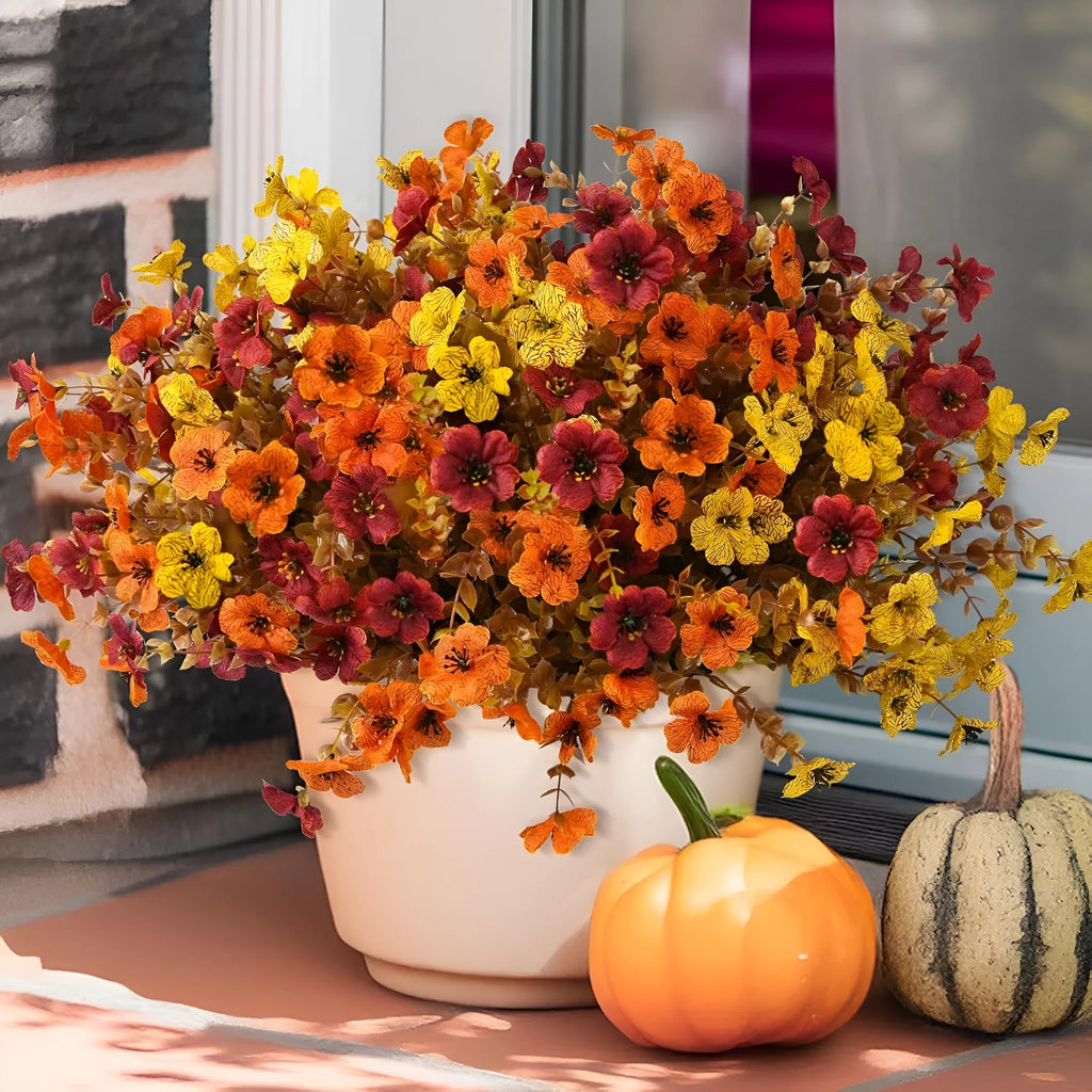 Artificial flower bouquet in autumn colours of red, yellow, orange, and orange yellow for home decoration