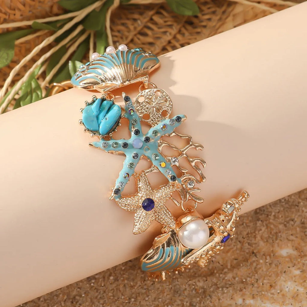 Women's alloy bracelet with marine shell, boat anchor, and starfish design in blue, red, or turquoise.