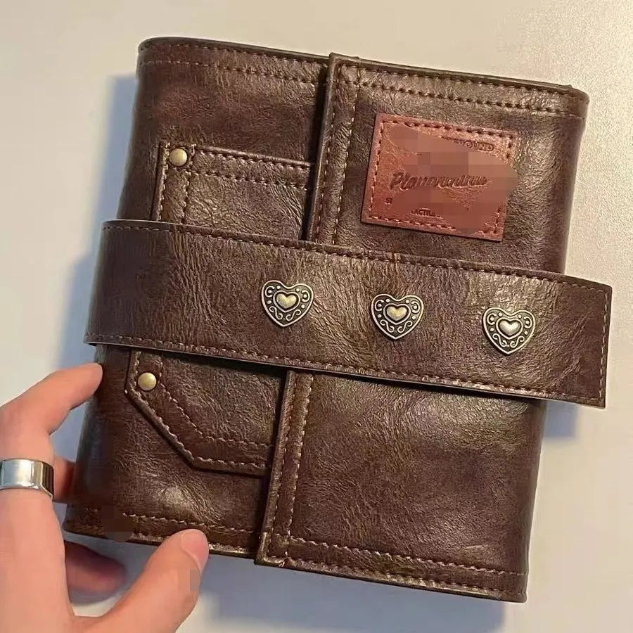 Brown retro leather-look PU cover A7 notebook with loose-leaf binder binding open on a desk.