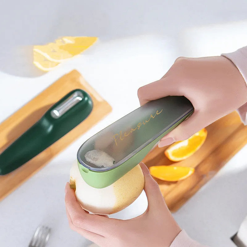 Dark green kitchen peeler with a storage tube and stainless steel blade, shown next to a potato.