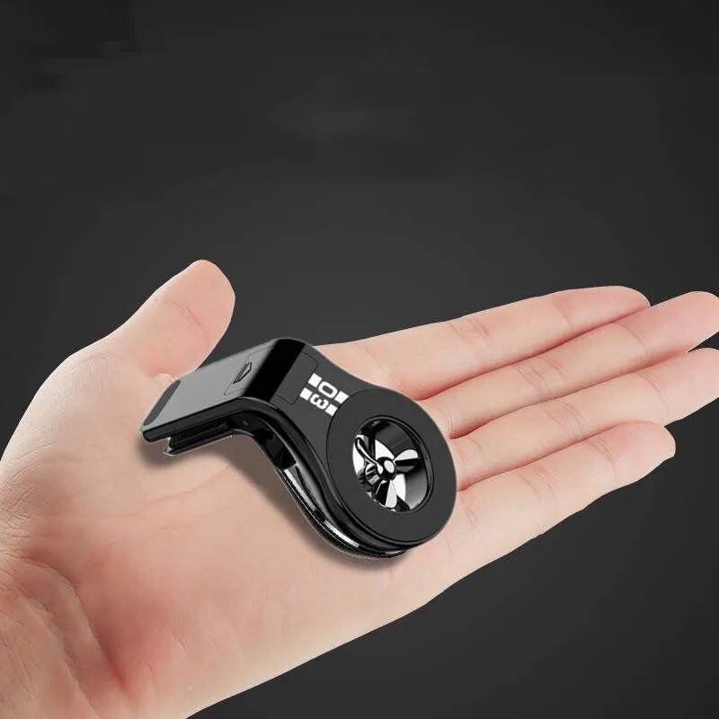 Black magnetic car phone holder attached to a car air vent, holding a smartphone at an angle.