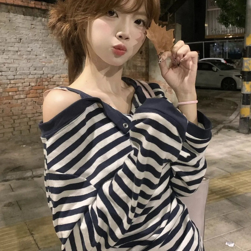 Dark blue women's long-sleeved oversized T-shirt with embroidery and striped detail on a hanger.