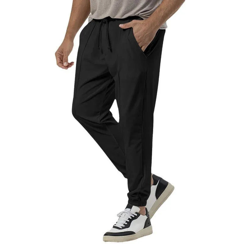 Men's grey tapered track sweatpants with straight-leg design and elastic waistband