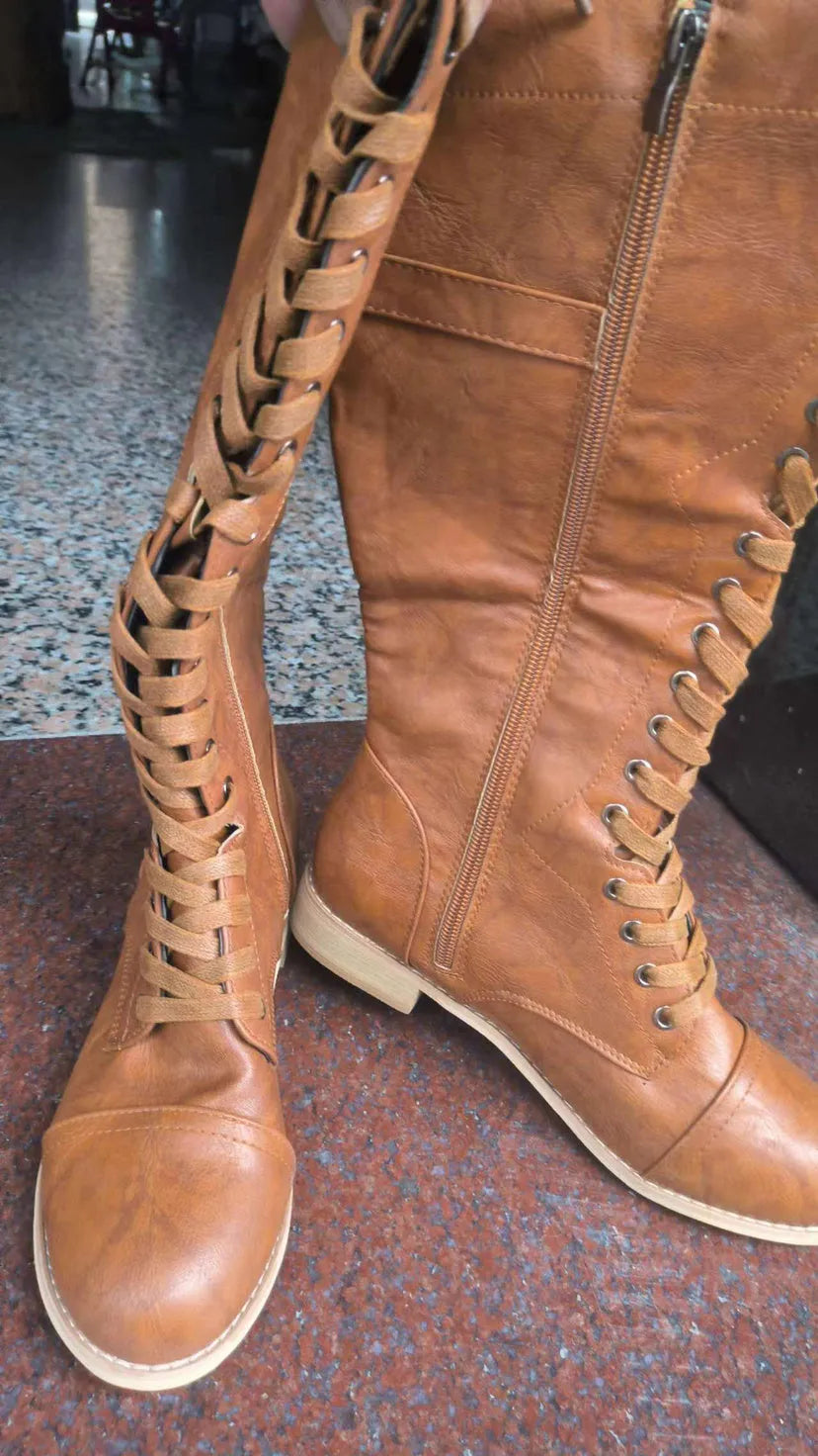 Women's black ankle boot with a cross strap design and zip fastening on the side.