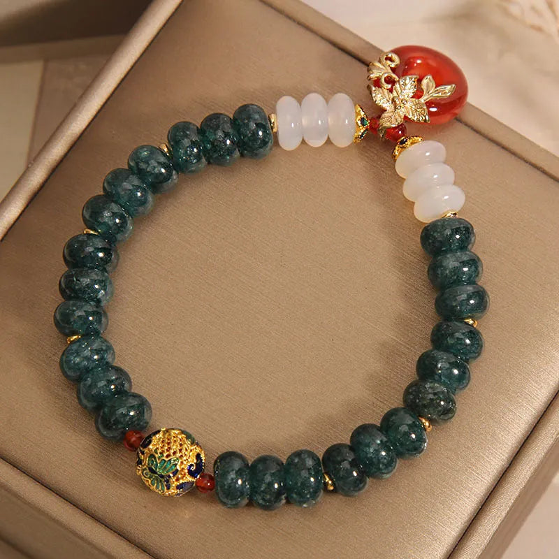 Blue water jade and red agate beaded bracelet with a peace symbol buckle clasp.
