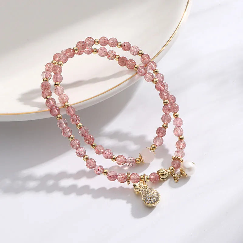Women's strawberry quartz crystal bracelet with geometric design on wrist