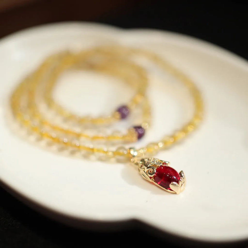 Handmade bracelet with Brazilian rutilated quartz beads, three gold circles, and a hanging bead pendant.