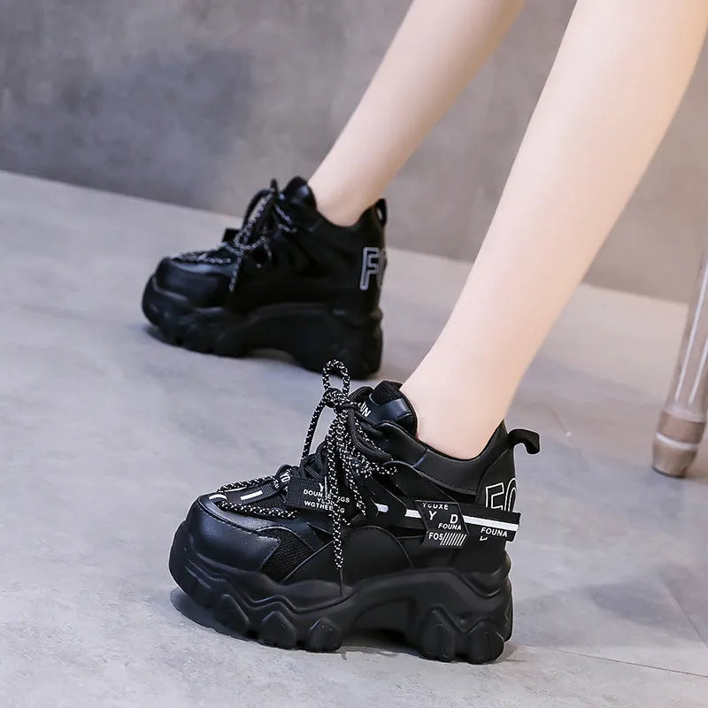 White women's low-top mesh sneakers with a black cross strap and a thick rubber platform sole.
