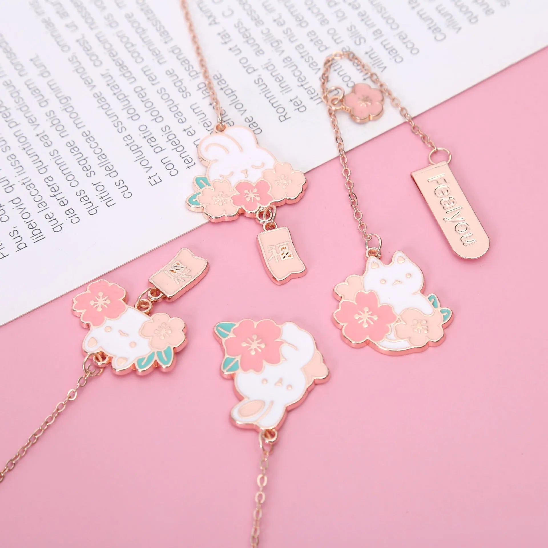 Small metal pendant bookmark with cartoon Sakura cat or cherry blossom rabbit illustration.