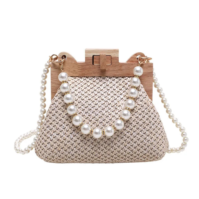 Women's woven straw shoulder bag with pearl chain detail in beige, showing horizontal square shape and single strap.
