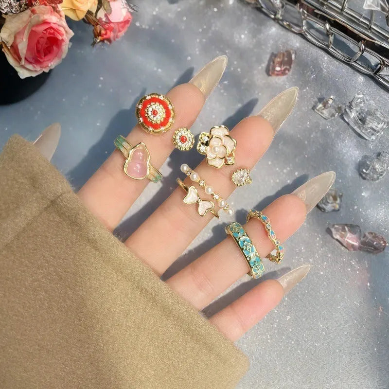 Adjustable copper ring with vintage oil dripping finish showing gourd, flower and bow design with inlaid zircon stones.