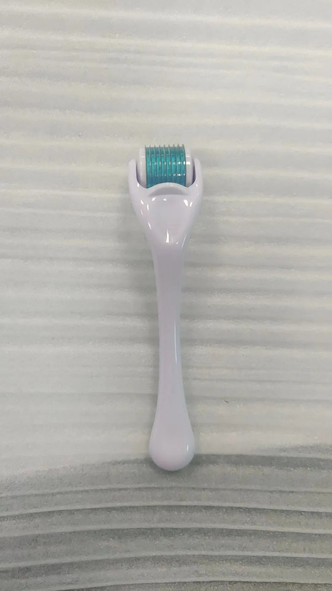 Sterile 540 micro needle derma roller showing handle and needle wheel in assorted colours.