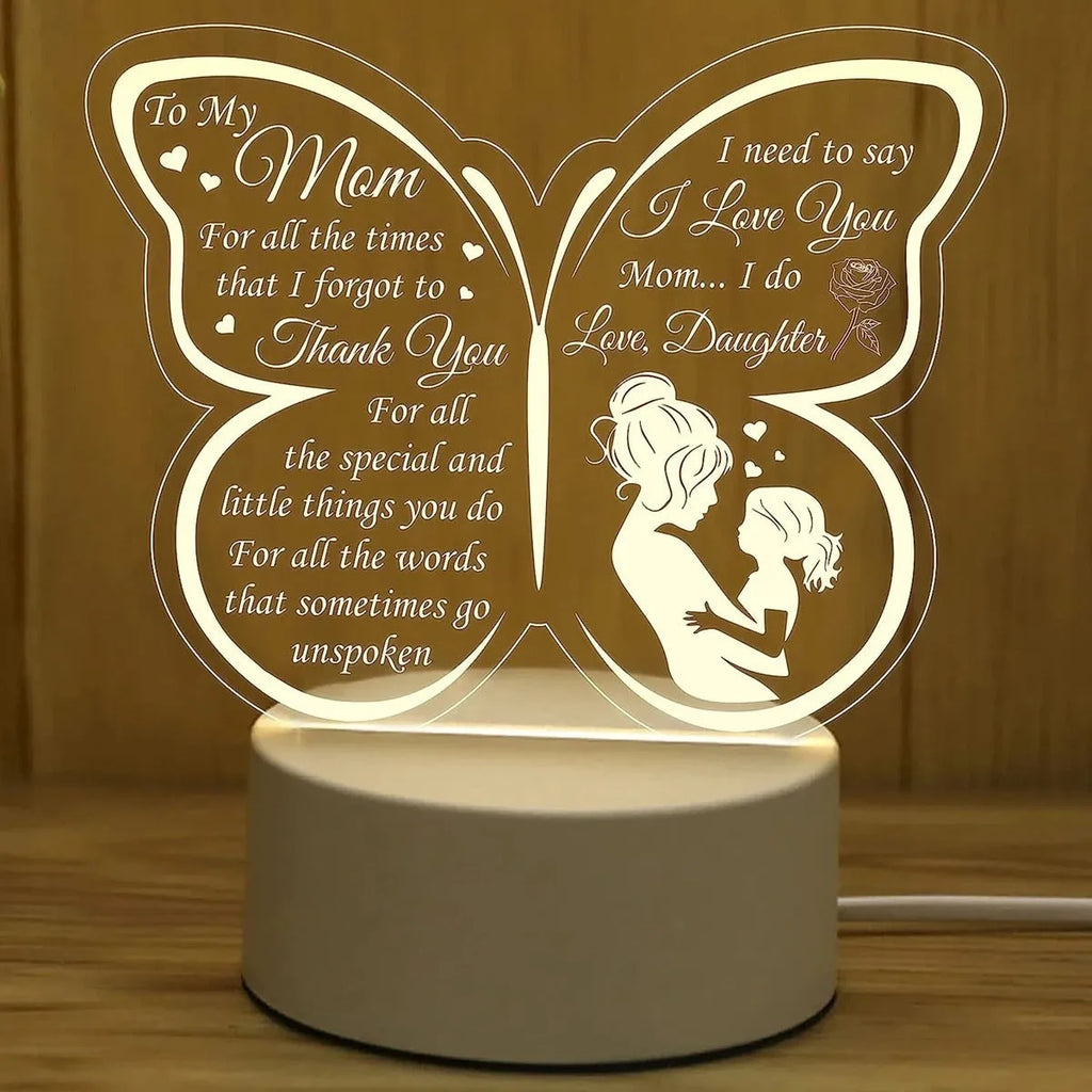 Clear acrylic heart-shaped table lamp with warm white light on a table.