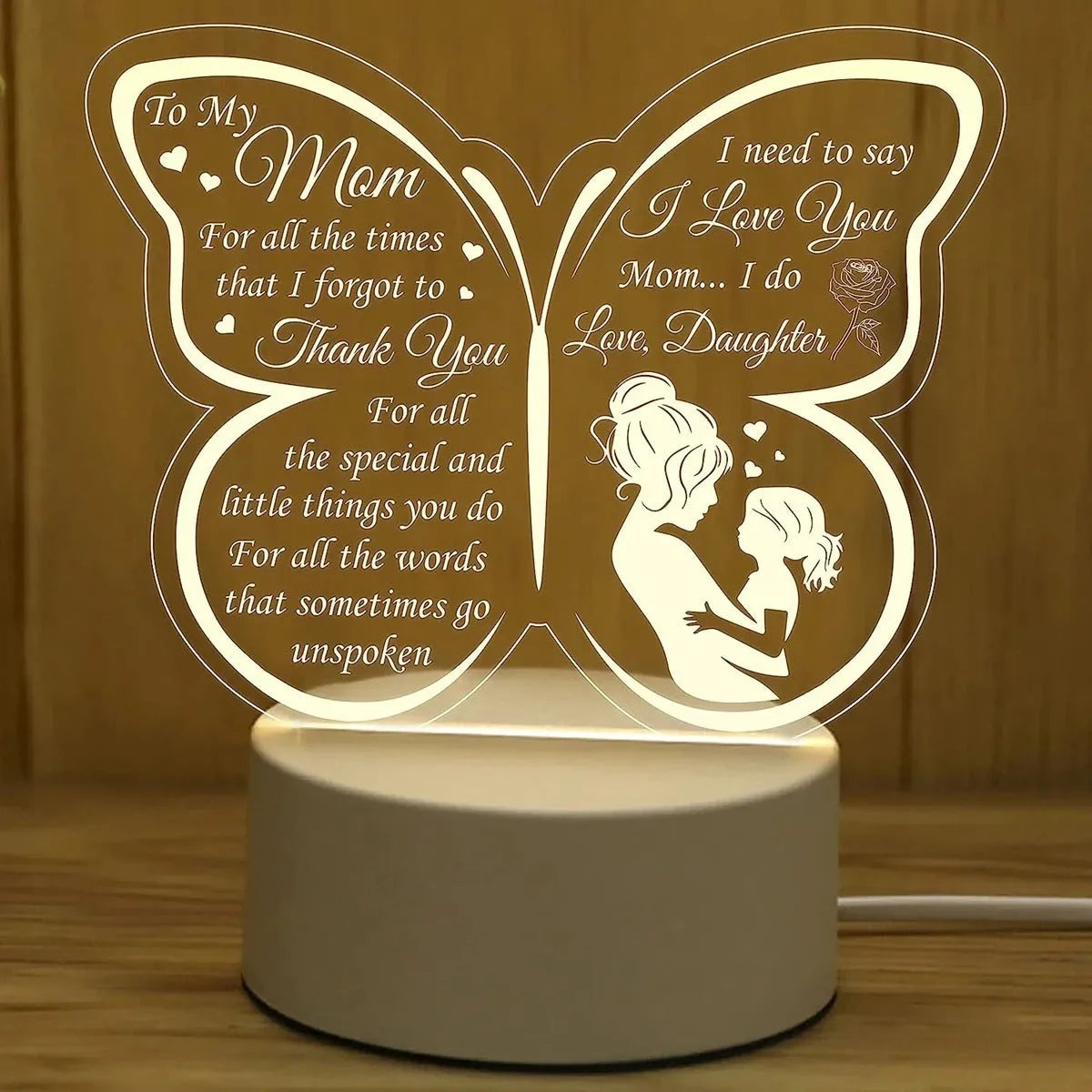 Clear acrylic heart-shaped table lamp with warm white light on a table.