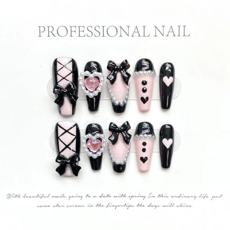Hand-painted black and pink peach heart false nails with bow designs and cat's eye finish in four sizes