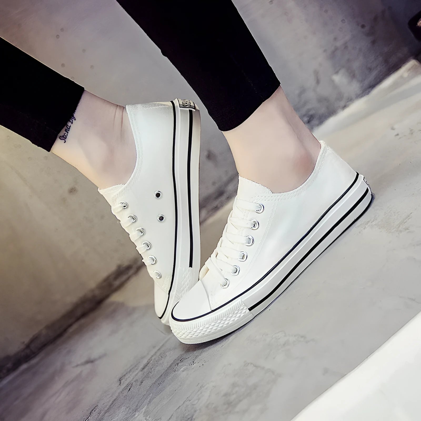 Women's solid-colour canvas shoes in black, shown on a foot from a side angle.