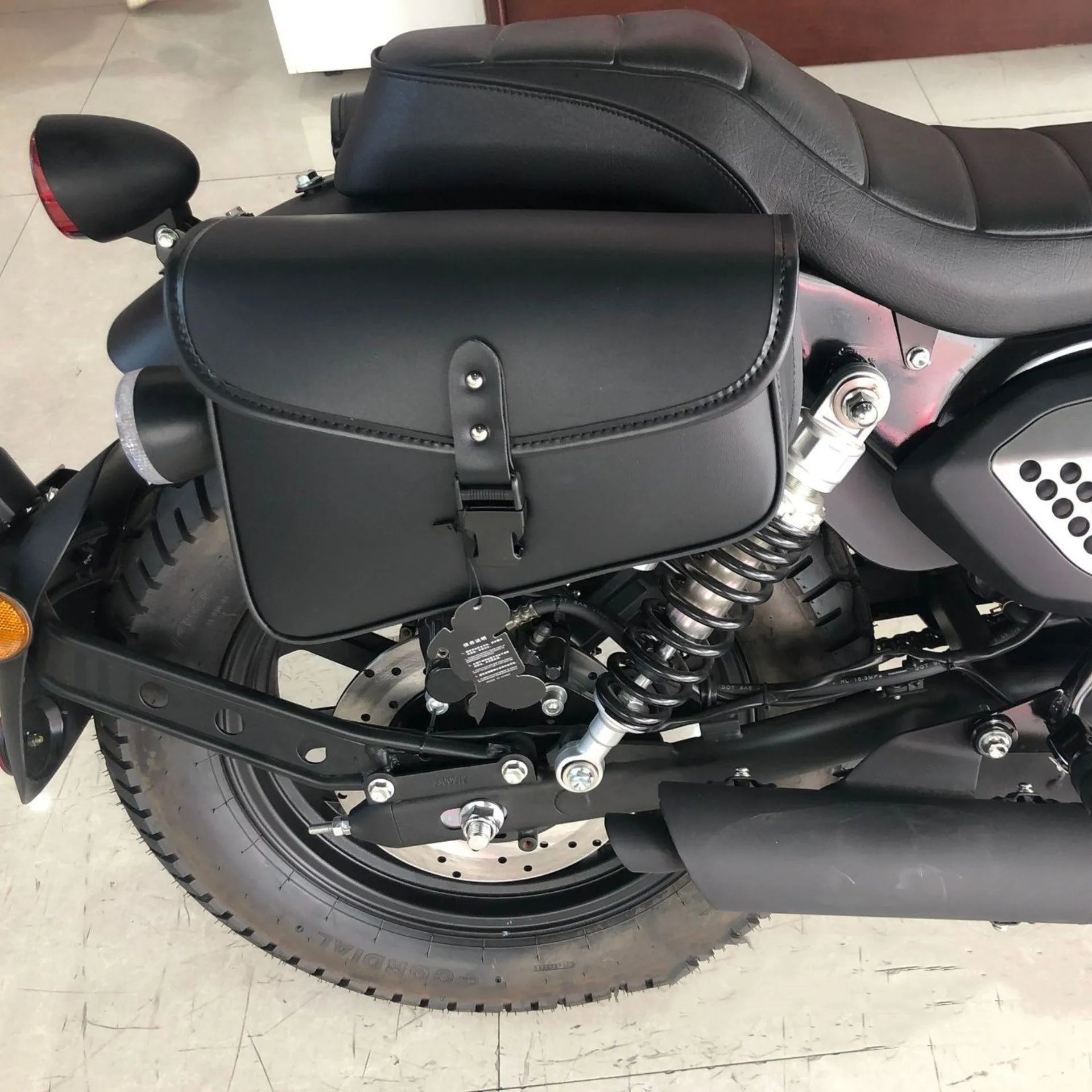 Black PU leather motorcycle swingarm side saddlebag mounted on a Sportster, showing its storage capacity.