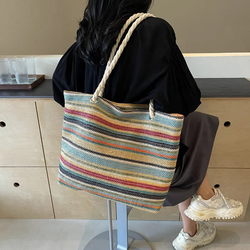 Blue woven nylon shoulder bag with adjustable strap showing straw-like texture pattern