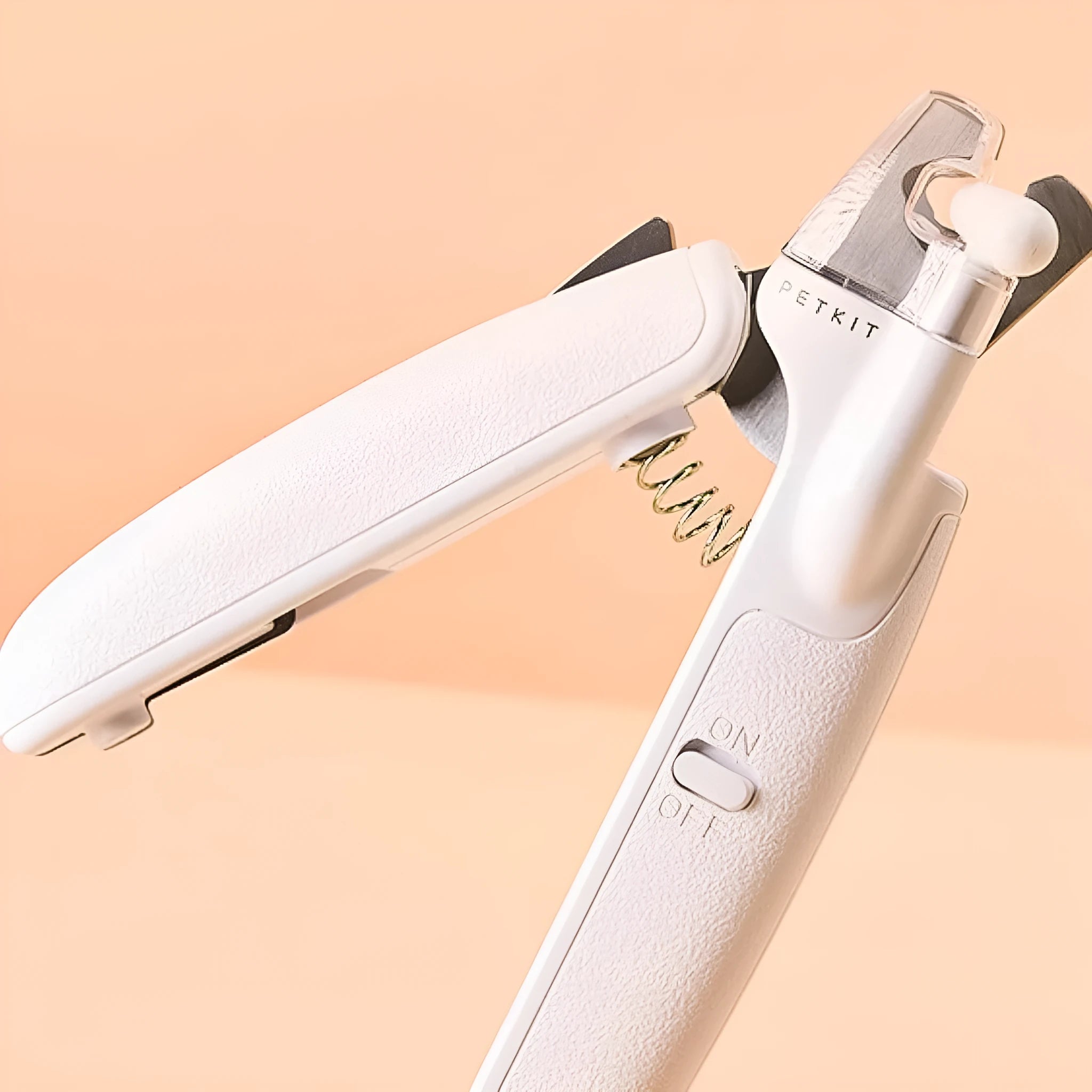 White pet nail clippers with LED light, transparent anti-splash guard, and integrated nail file on a grey background.