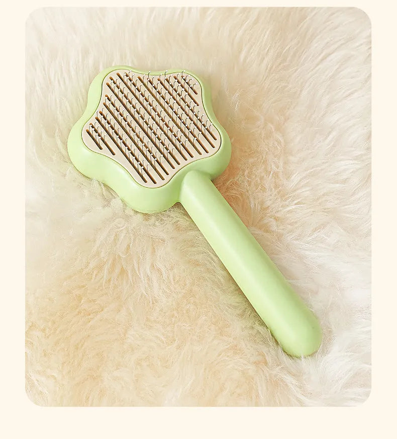 Green self-cleaning magic wand cat comb with stainless steel needle teeth on a white background.