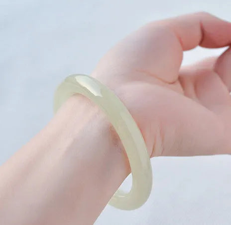 Round bar jade bracelet with geometric winding silk jade design, shown in a listed inner diameter size