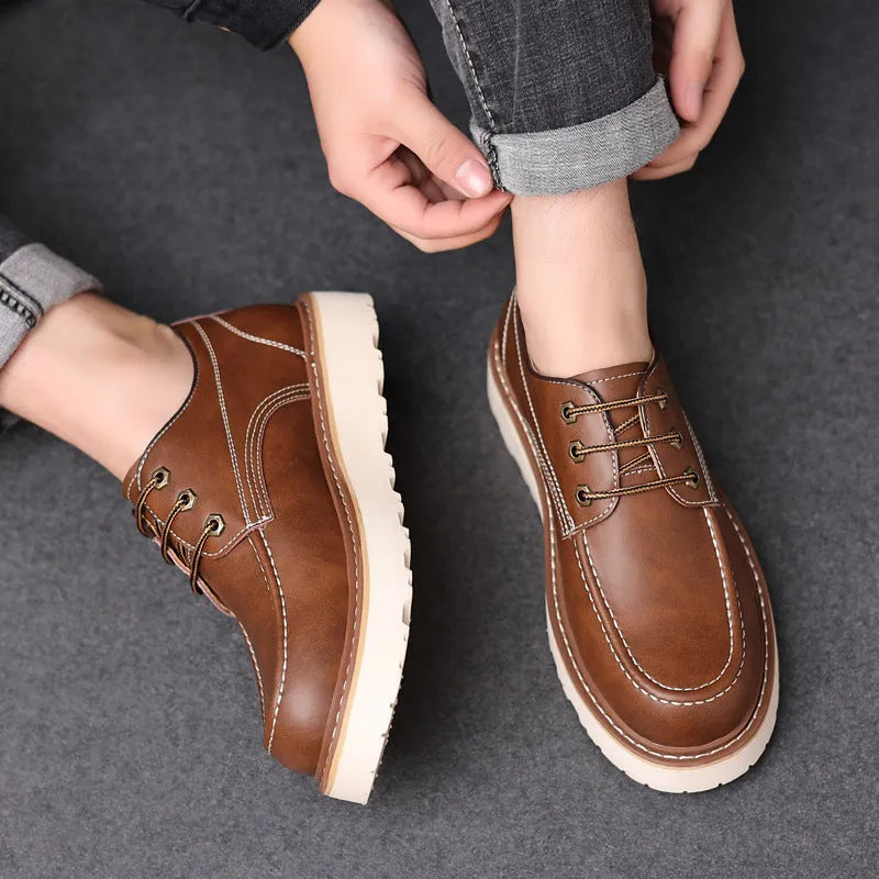 Men's black retro low-top Martin boots with a rounded toe and rubber sole on a plain background.