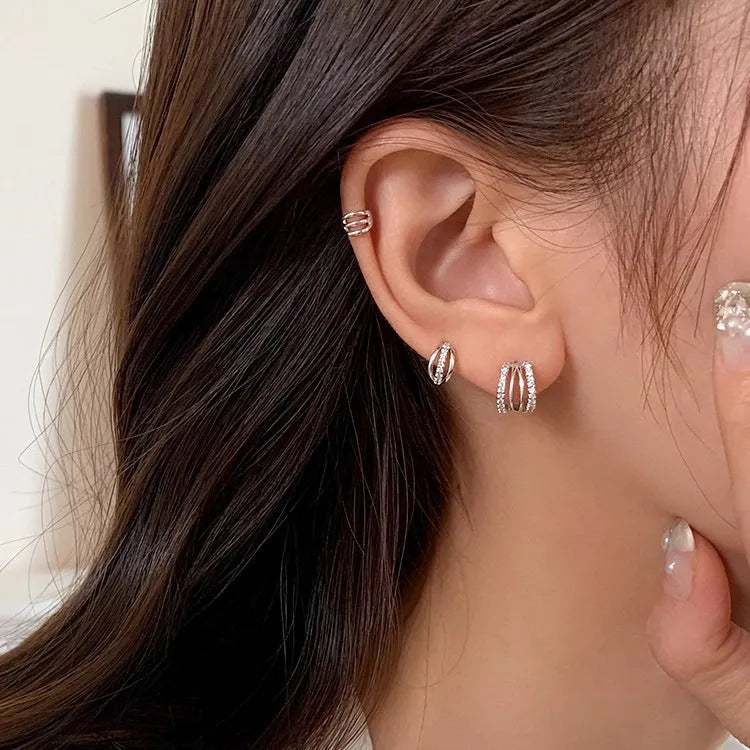 A pair of geometric-shaped 925 silver needle earrings with an electroplated metallic finish.