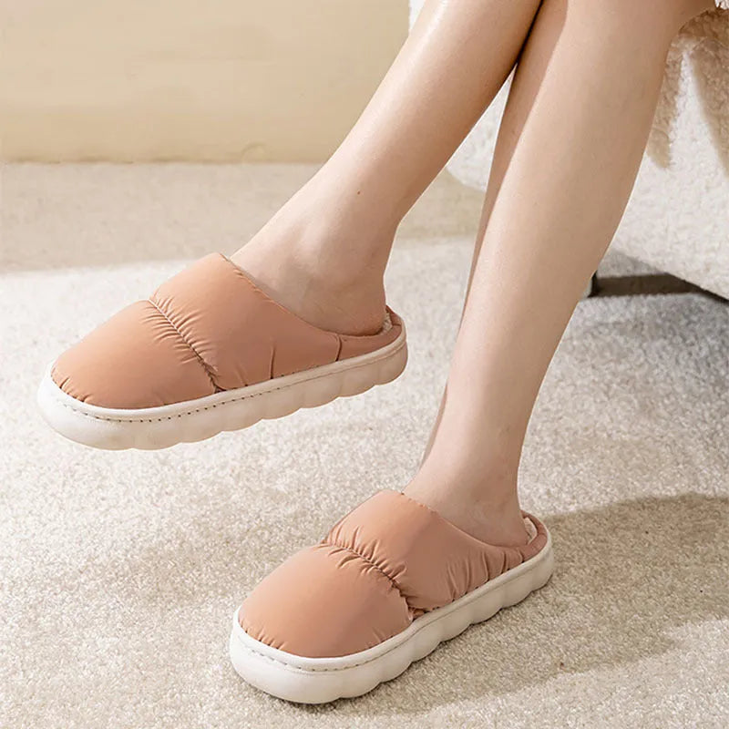 A pair of down cotton slippers with a thick rubber sole and artificial leather upper in a selected colour.