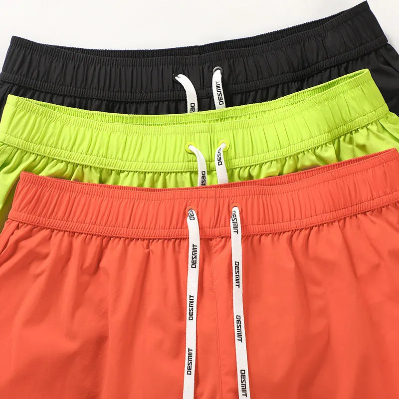 Men's loose polyester beach shorts in orange red, fluorescent green, or black colours